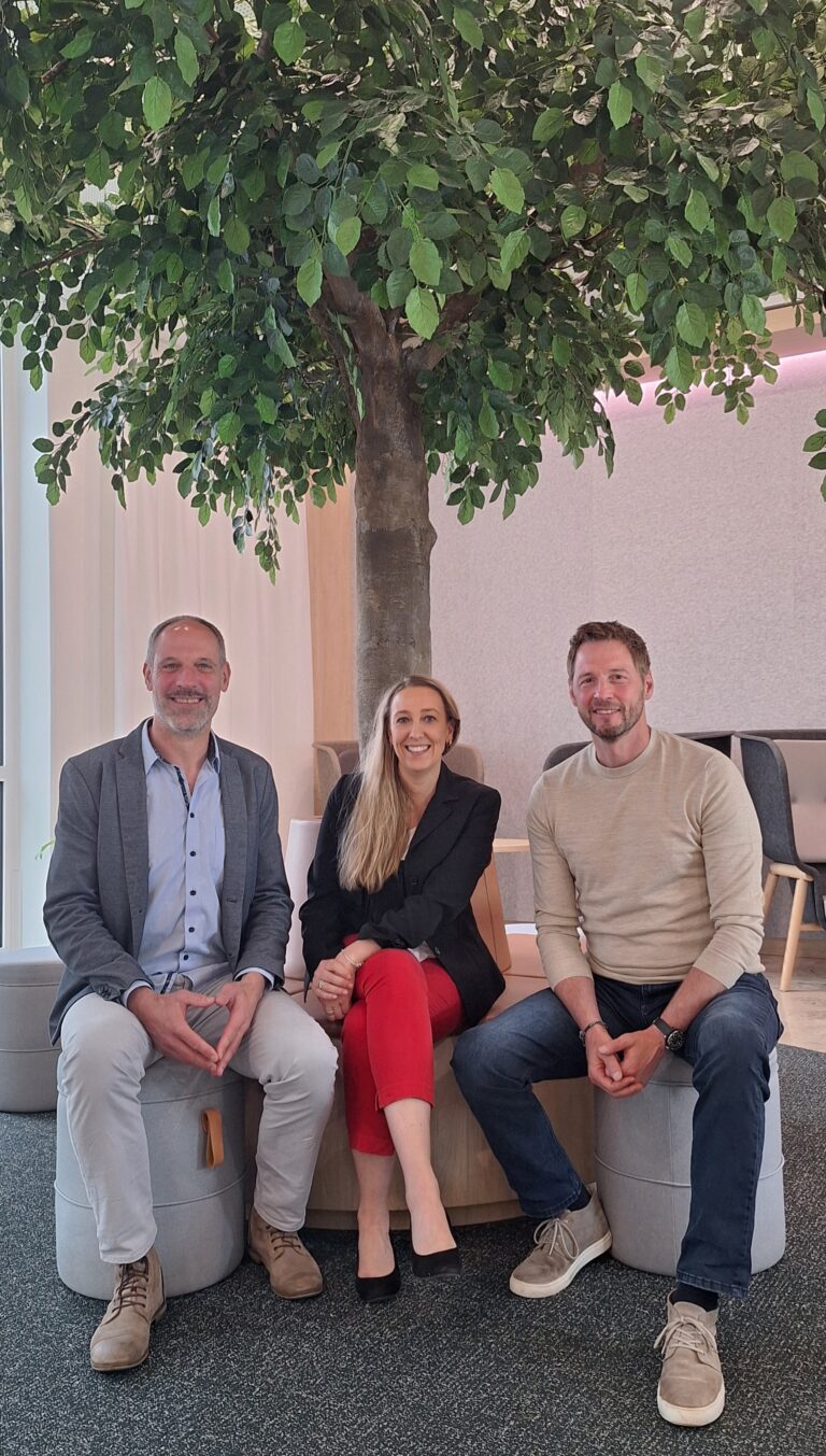Guido Berghoff, Sandra Kisters-Nuderscher und Dieter Könnes sitzen unter einem Baum